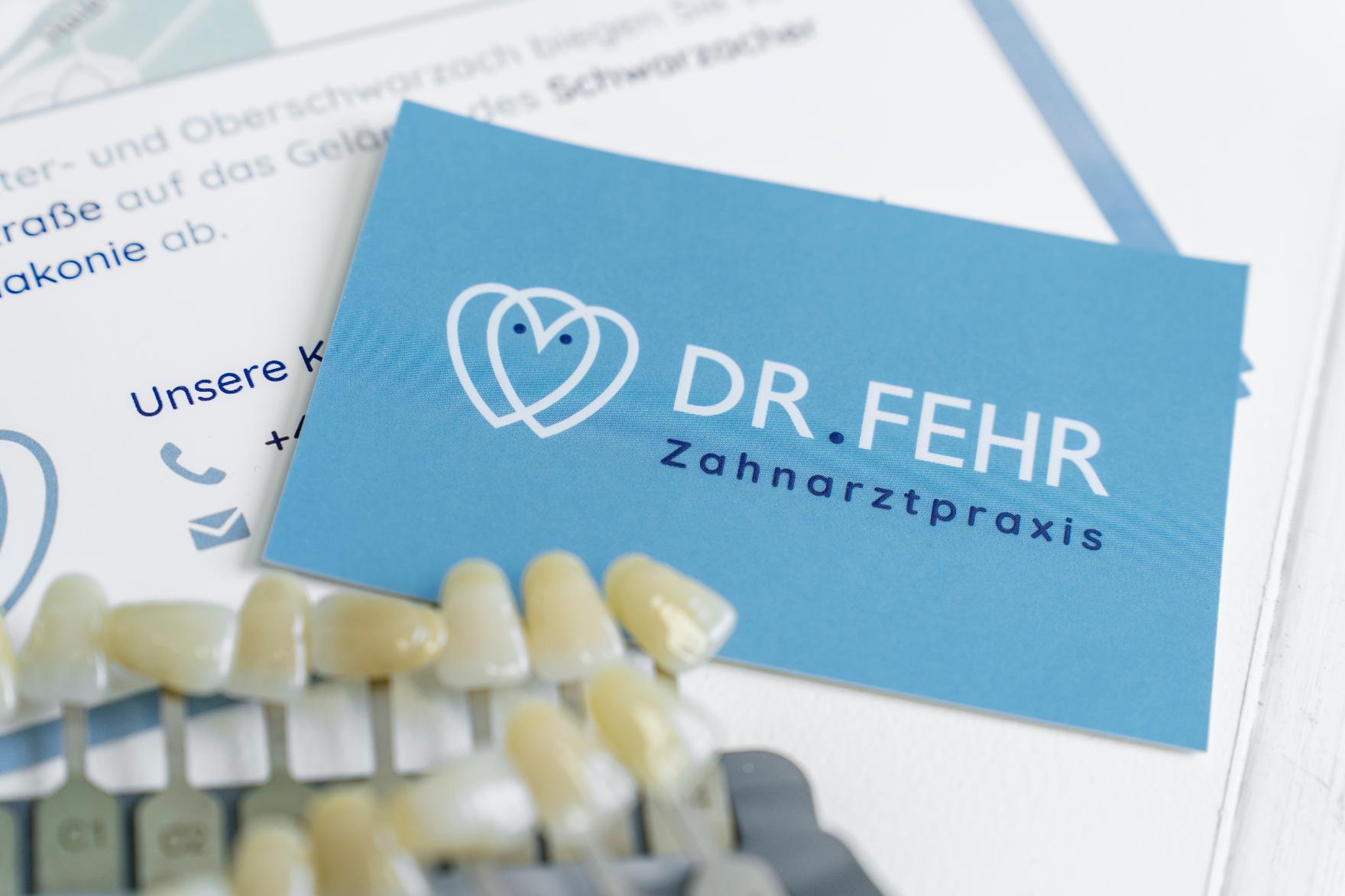 022 Visitenkarte der Zahnarztpraxis Dr. Fehr neben einem Zahnmodell